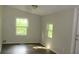 Well-lit bedroom featuring two windows and wood flooring at 214 W Dade Ave, Bushnell, FL 33513