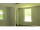 Well-lit bedroom with two windows and ceiling fan at 214 W Dade Ave, Bushnell, FL 33513