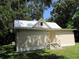 Cute cottage style home with a metal roof and mature trees at 214 W Dade Ave, Bushnell, FL 33513