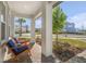 Covered front porch with two wooden chairs and a side table at 10063 Pearson Ave, Orlando, FL 32827