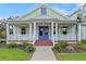 Front view of a charming house with a porch and purple door at 1162 Fiesta Key Cir, Lady Lake, FL 32159