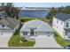 Aerial view of a single-story house with a three-car garage and lakefront access at 2740 Alder Ave, Middleton, FL 34762