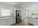 Bright kitchen featuring stainless steel refrigerator, granite countertops, and white cabinets at 2740 Alder Ave, Middleton, FL 34762