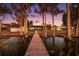 Wooden dock leads to a house on the lake at sunset at 648 Banning Beach Rd, Tavares, FL 32778