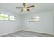Spacious bedroom with two windows, ceiling fan, and light grey laminate flooring at 6607 Kreidt Dr, Orlando, FL 32818