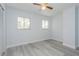 Bright bedroom with two windows, ceiling fan, and light grey laminate flooring at 6607 Kreidt Dr, Orlando, FL 32818