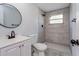 Modern bathroom with a walk-in shower, white vanity, and grey tile at 6607 Kreidt Dr, Orlando, FL 32818