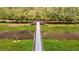 Boardwalk over water with lush green vegetation on both sides at 1180 Dora Parc Ln, Mount Dora, FL 32757