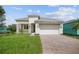 Single-Gathering home with a white exterior, gray roof and paver driveway at 1180 Dora Parc Ln, Mount Dora, FL 32757