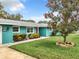 Ranch style teal home with a red door and nicely landscaped yard at 1559 Lakeshore Dr, Eustis, FL 32726