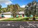 Ranch style home with teal exterior and manicured lawn at 1559 Lakeshore Dr, Eustis, FL 32726