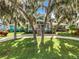 Teal home with a red door, landscaping, and a circular driveway at 1559 Lakeshore Dr, Eustis, FL 32726