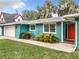 Bright teal house with a red front door, and nicely manicured lawn at 1559 Lakeshore Dr, Eustis, FL 32726