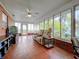 Relaxing sunroom with tiled floors, brick walls, and comfortable furniture at 1559 Lakeshore Dr, Eustis, FL 32726
