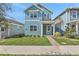 Two-story light blue house with green door, landscaping, and walkway at 3018 Mirage Pl, St Cloud, FL 34771