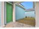 Green door, light blue exterior walls, and a small grassy side yard at 3018 Mirage Pl, St Cloud, FL 34771