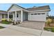 Front exterior view of a light blue, single-story home with a white garage door and brick paver driveway at 3108 Expedition Dr, Saint Cloud, FL 34771