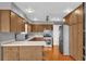 Galley style kitchen with wood cabinets, stainless steel appliances, and wood flooring at 7373 Circle Dr, Lady Lake, FL 32159