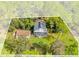 Aerial view of house and detached garage on a wooded waterfront lot at 7373 Circle Dr, Lady Lake, FL 32159