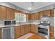 Kitchen features wood cabinets, stainless steel appliances, and a window overlooking the backyard at 7373 Circle Dr, Lady Lake, FL 32159