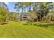 Two-story house with a large grassy yard and lush trees at 7373 Circle Dr, Lady Lake, FL 32159