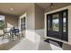 Inviting porch with a small table and chairs, next to a black front door at 4049 Nostalgia Ter, The Villages, FL 32163