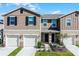 Two-story townhome with attached garages and landscaping at 1496 Mirabella Cir, Davenport, FL 33897