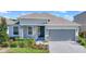 One-story home with gray siding, stone accents, and a two-car garage at 2380 Sirena Ln, Mount Dora, FL 32757