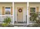 Inviting front porch with wreath, white railing, and potted plants at 218 Ann St, Lady Lake, FL 32159