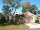 Tan one-story house with two-car garage and landscaped yard at 4300 Hammersmith Dr, Clermont, FL 34711