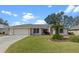 One-story house with attached garage and landscaped yard at 5729 King James Ave, Leesburg, FL 34748