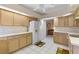 Galley style kitchen with wood cabinets and white appliances at 5729 King James Ave, Leesburg, FL 34748
