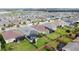 Aerial view of a community with houses, solar panels, and lush landscaping at 518 Narrow View Ln, Groveland, FL 34736