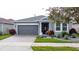 Gray house with a two-car garage and landscaping at 518 Narrow View Ln, Groveland, FL 34736