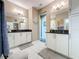 Double vanity bathroom with granite countertops and a large mirror at 518 Narrow View Ln, Groveland, FL 34736