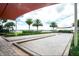 Outdoor bocce ball court with palm trees and shade structure at 518 Narrow View Ln, Groveland, FL 34736