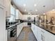 Modern kitchen with white cabinets, granite countertops and stainless steel appliances at 518 Narrow View Ln, Groveland, FL 34736