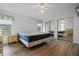 Main bedroom with wood-look floors, mirrored closet, and a queen-size bed at 1020 Hilltop Rd, Tavares, FL 32778