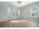 Bright bedroom with wood-look floors and multiple windows at 2105 Lula Rd, Minneola, FL 34715