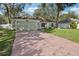 Single-story house with a green painted garage and a well-maintained lawn at 34321 Shadewood Cir, Leesburg, FL 34788