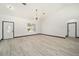 Bright living room with high ceilings, hardwood floors, and a modern chandelier at 3610 Se 131St Ln, Belleview, FL 34420