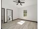 Bedroom with ceiling fan, wood-look floors, and bathroom access at 3610 Se 131St Ln, Belleview, FL 34420