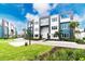 Modern townhouses with landscaped grounds and a curved driveway at 7740 Sandy Ridge Dr # 106, Reunion, FL 34747
