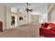 Open living room with a red couch and view of kitchen at 815 Forest Breeze Path, Leesburg, FL 34748