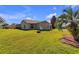House back view with grassy yard and palm trees at 815 Forest Breeze Path, Leesburg, FL 34748