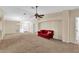 Living room with red couch and view of the front door at 815 Forest Breeze Path, Leesburg, FL 34748