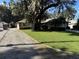 Front view of a single story house with a driveway and a lush lawn at 2494 County Road 447, Lake Panasoffkee, FL 33538