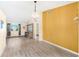 Bright dining room features wood-look floors, a chandelier, and a mustard yellow accent wall at 2411 Greenlaw Ct, Leesburg, FL 34788