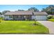 Cute ranch home with a screened porch, landscaped yard, and a two-car garage at 2411 Greenlaw Ct, Leesburg, FL 34788