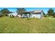 Large backyard with grassy area and home view at 2411 Greenlaw Ct, Leesburg, FL 34788